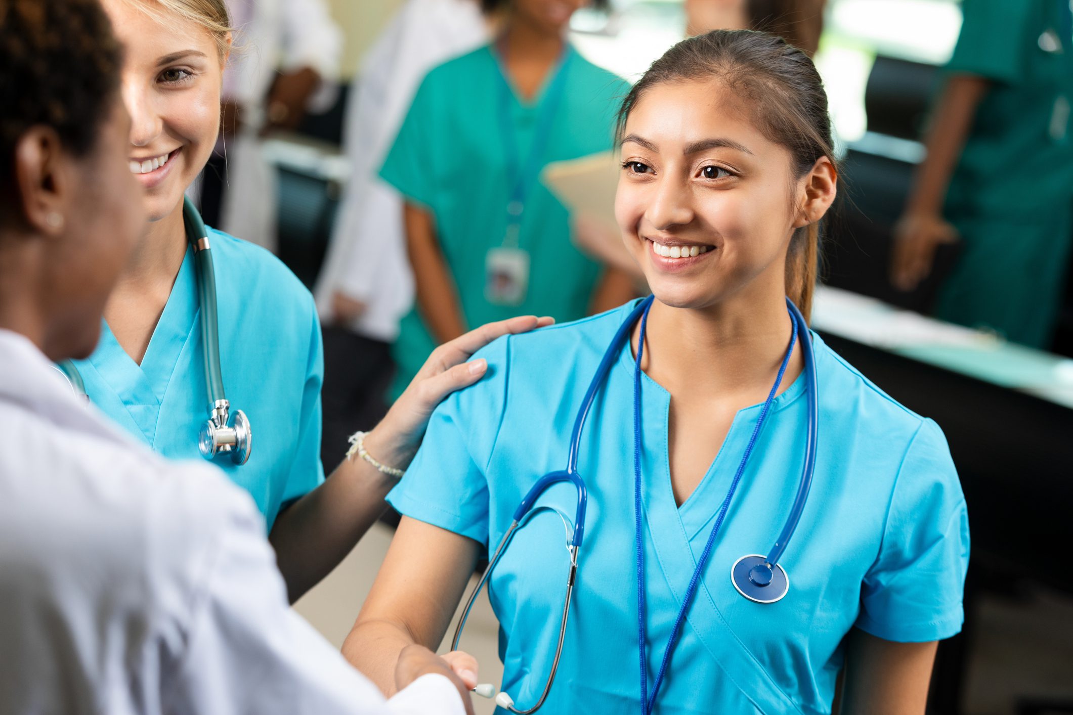 Nurses in blue scrubs smiling